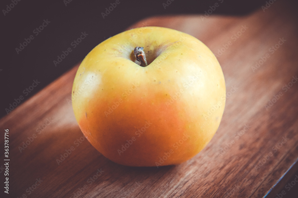Apple on wooden cutting board