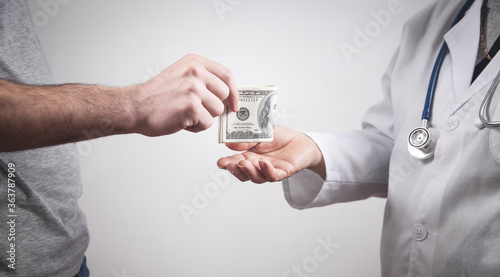 Patient giving bribe to doctor in clinic.
