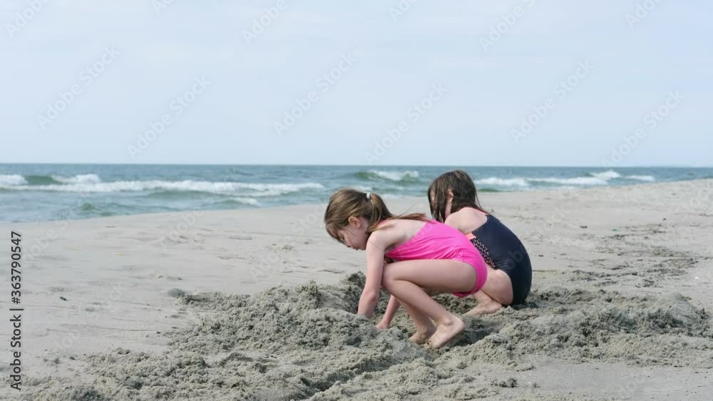 little children play in the sand on the beach on the Baltic Sea little children play in the sand on the beach on the Baltic Sea