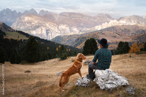 man with a dog in the mountains. travel, hiking with a pet. Nova Scotia Duck Tolling Retriever © annaav