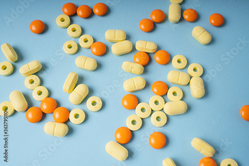 Top view - yellow and orange pills over blue background.