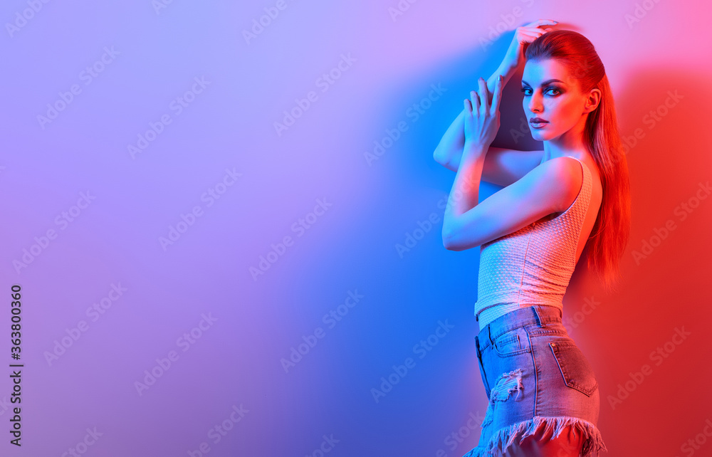 High Fashion. Woman in colorful neon light, make-up. Sexy redhead girl, stylish hair, trendy shorts. Party disco neon style. Creative art beauty concept, fashionable slim model, bright make up High Fashion. Woman in colorful neon light, make-up. Sexy redhead girl, stylish hair, trendy shorts. Party disco neon style. Creative art beauty concept, fashionable slim model, bright make up