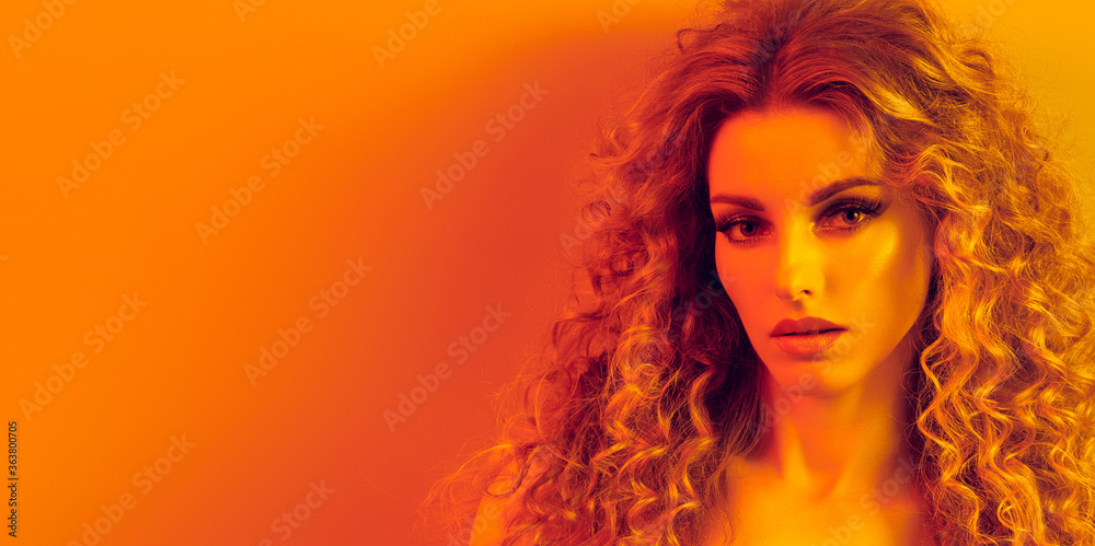 High Fashion. Woman in colorful neon gold light, make-up. Sexy blond girl, stylish curly hair, trendy makeup. Golden neon portrait. Creative beauty, fashionable model face, voluminous hairstyle High Fashion. Woman in colorful neon gold light, make-up. Sexy blond girl, stylish curly hair, trendy makeup. Golden neon portrait. Creative beauty, fashionable model face, voluminous hairstyle