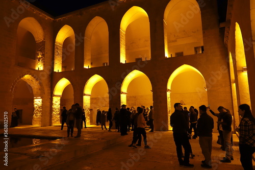 Mardin Artuklu ilçesinde bulunan tarihi Kasımiye Medresesinde ışık, insan ve yansıma photo