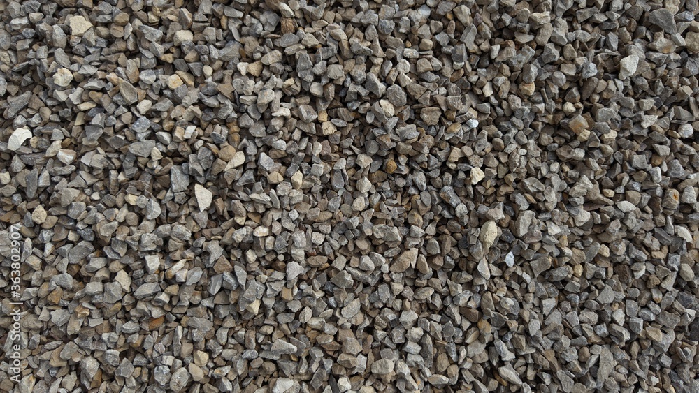The texture of stone gravel gray. Stone rubble gray poured pile close-up.