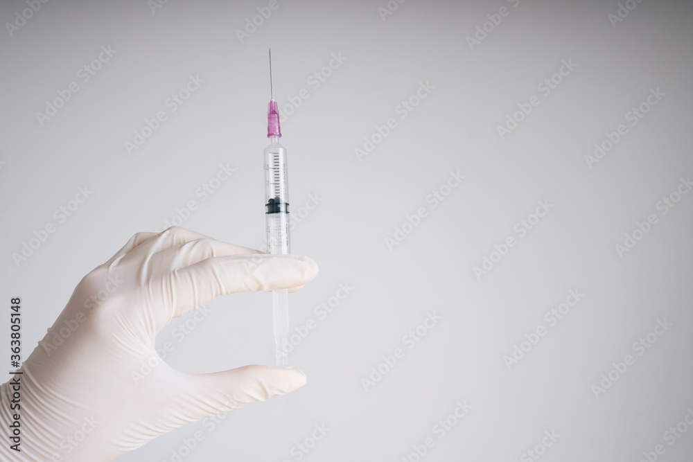 Doctor plastic gloves hand holding using syringe isolate over white background. Doctor plastic gloves hand holding using syringe isolate over white background.