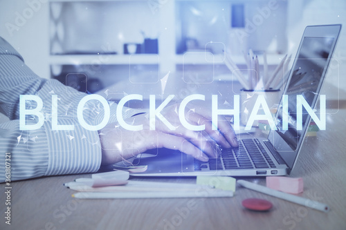 Blockchain theme hud with businessman working on computer on background. Concept of crypto chain. Double exposure.