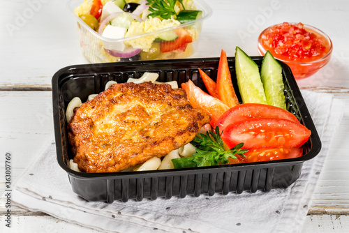 Cutlet with pasta, vegetables in a black container