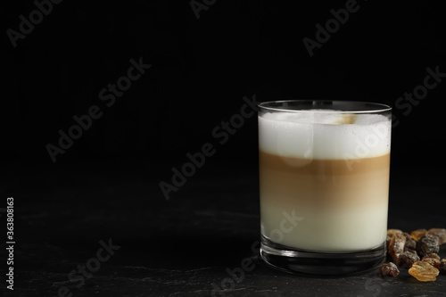 Delicious latte macchiato on table against black background, space for text