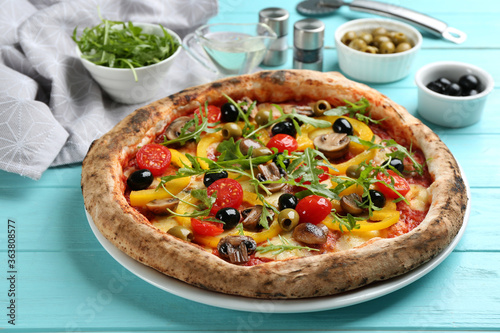 Delicious vegetable pizza on light blue wooden table