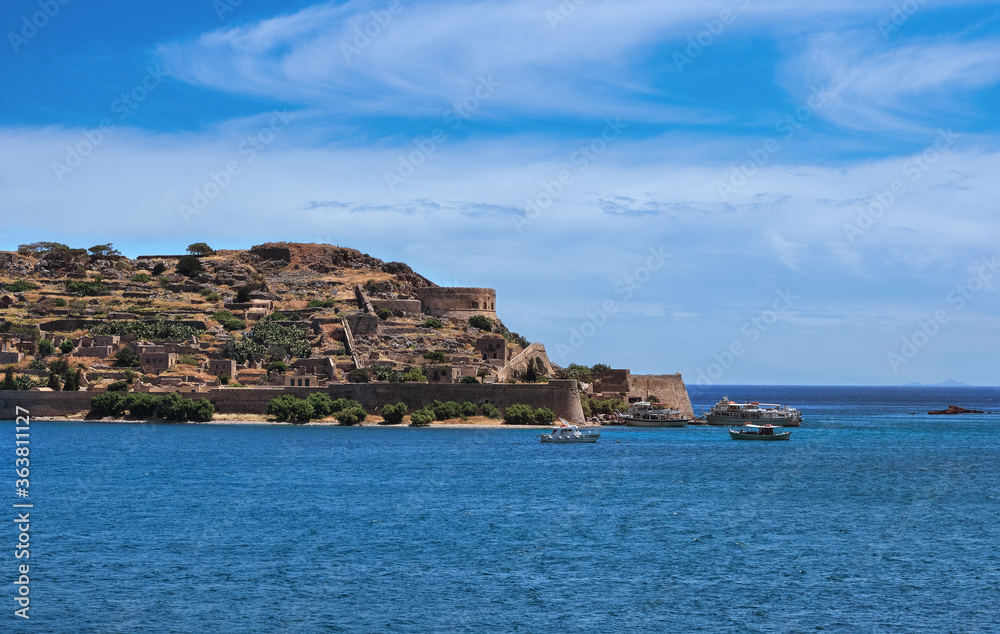 View of west bank of Spinalonga island and Venetian fortress on clear sunny summer day, Crete, Greece View of west bank of Spinalonga island and Venetian fortress on clear sunny summer day, Crete, Greece