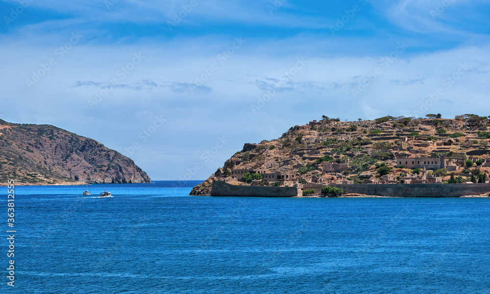 View of west bank of Spinalonga island and Venetian fortress on clear sunny summer day, Crete, Greece
