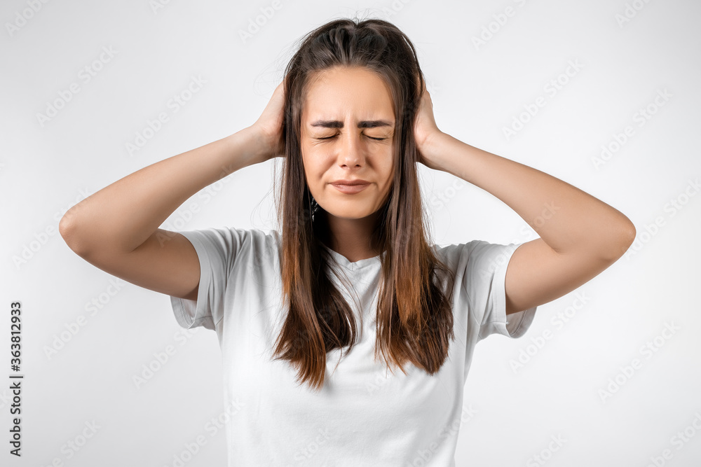 Oh NO. Photo of beautiful girl with long chestnut hairs, with closes eyes, astonished holding hands on head. Problems, surprise, fear, fobia concept Oh NO. Photo of beautiful girl with long chestnut hairs, with closes eyes, astonished holding hands on head. Problems, surprise, fear, fobia concept