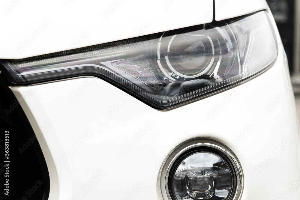 Car headlights. Luxury Headlights. Part of a white luxury car close up.