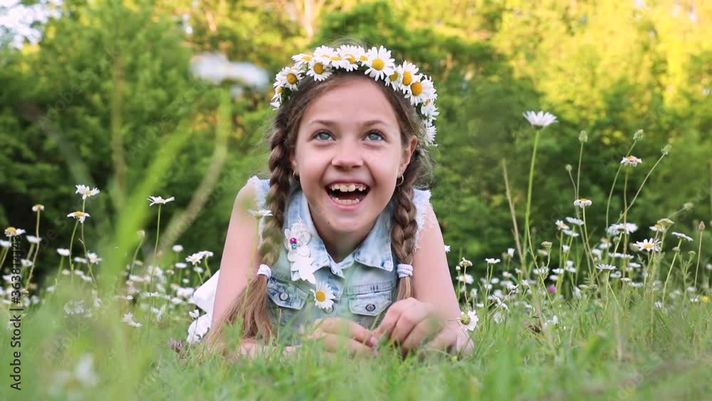 Cute little girl in summer dress lying on the grass. little girl and daisies Cute little girl in summer dress lying on the grass. little girl and daisies