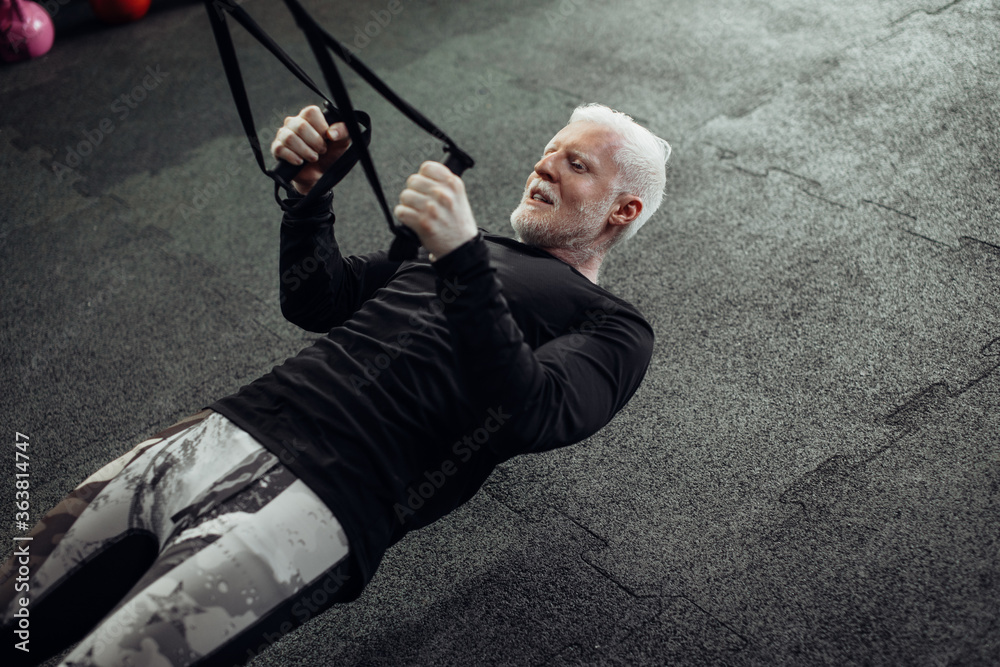 Senior man exercising at gym. Mature man doing push-ups Senior man exercising at gym. Mature man doing push-ups