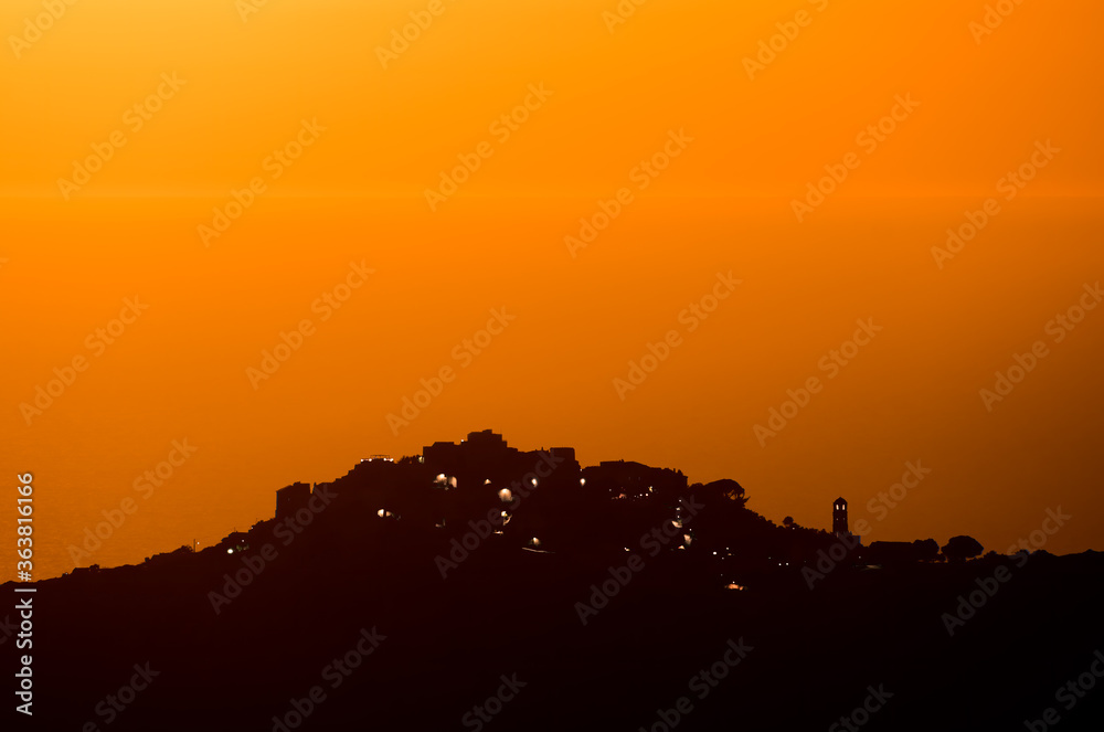  Sant'Antonino silhouetted by orange glow at sunset