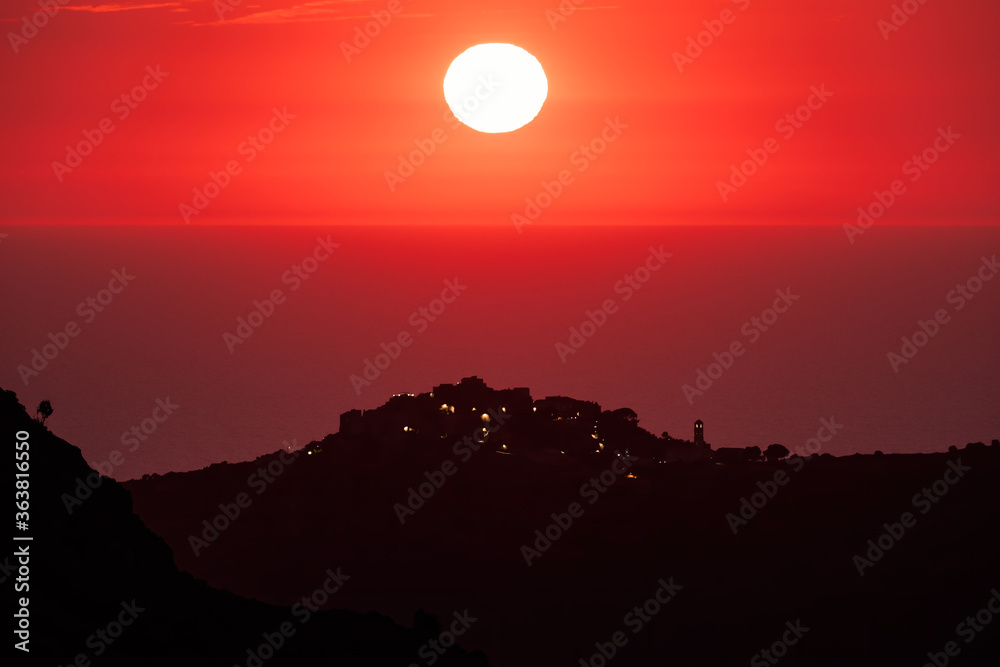 Sun setting over the village of Sant'Antonino and Mediterranean Sun setting over the village of Sant'Antonino and Mediterranean