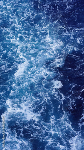 seething water. texture of blue foamy sea water. clear ocean water background. sun reflection