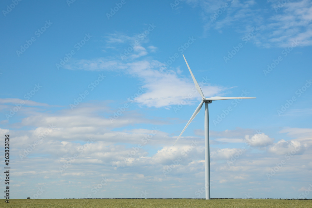 Beautiful view of field with wind turbine. Alternative energy source Beautiful view of field with wind turbine. Alternative energy source