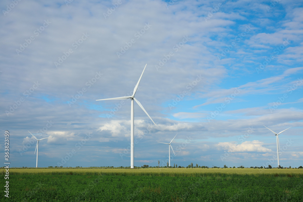 Beautiful view of field with wind turbines. Alternative energy source Beautiful view of field with wind turbines. Alternative energy source