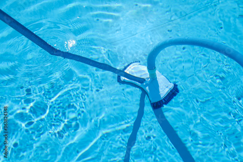 Cleaning outdoor pool with underwater vacuum, closeup