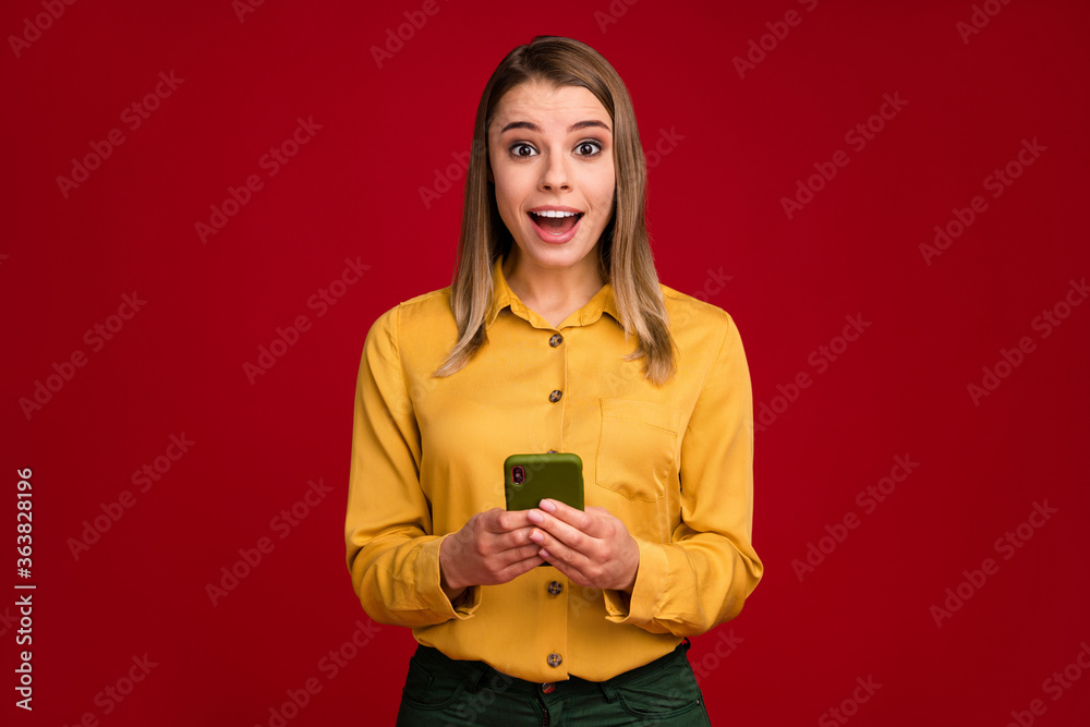 Fototapeta premium Portrait of her she nice attractive lovely charming amazed cheerful cheery girl using cell sale app fasts peed connection isolated over bright vivid shine vibrant red color background