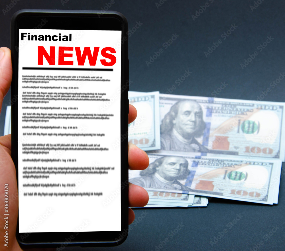 Φωτογραφία The smartphone on the screen the inscription financial news lies on dollars