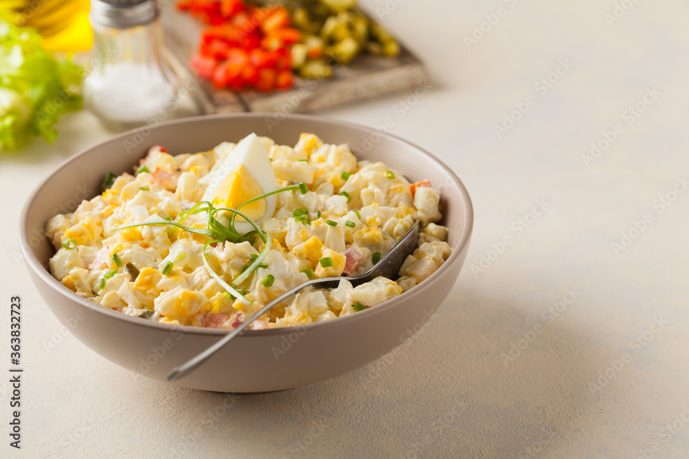 A light egg salad with celery, gherkin, pepper and mayonnaise. Served in a bowl on a light background. Front view. A light egg salad with celery, gherkin, pepper and mayonnaise. Served in a bowl on a light background. Front view.
