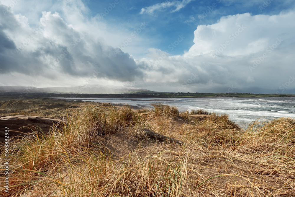 View from top of a dune on Atlantic ocean, Strandhill beach, county Sligo, Ireland, Warm sunny day, Cloudy sky, Nobody..