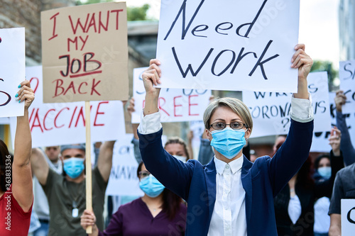 Businesswoman with protective face mask on a protest during coronavirus pandemic. © Drazen