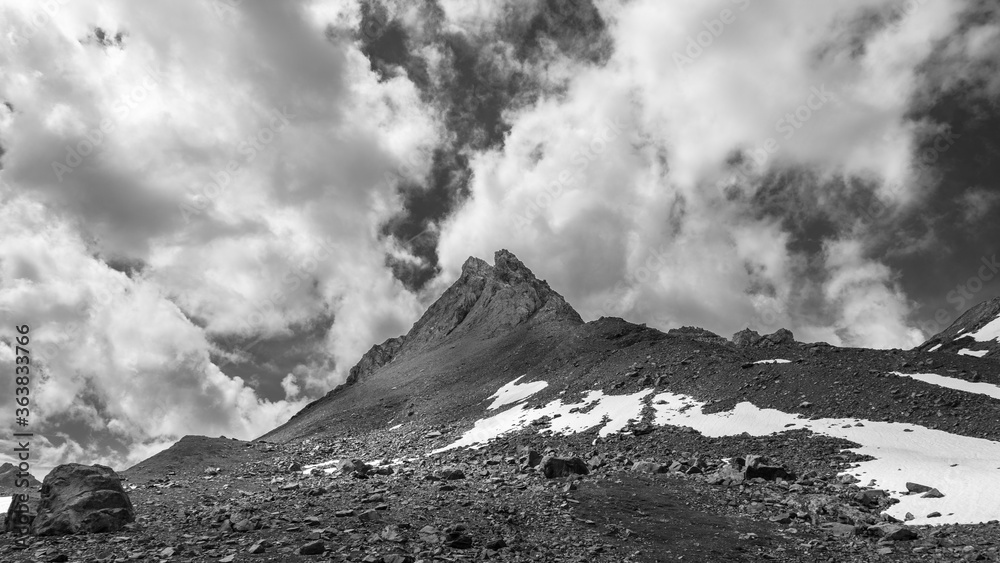 Mountain peak on a dramatic cloudy background, Italian Alps. Monochrome