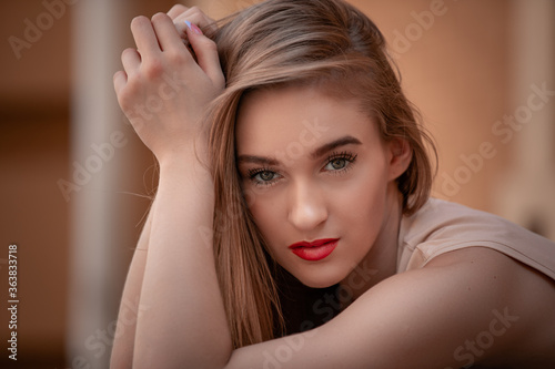 close-up portrait of a young girl hipster beautiful blonde with red lips posing against the backdrop of the city