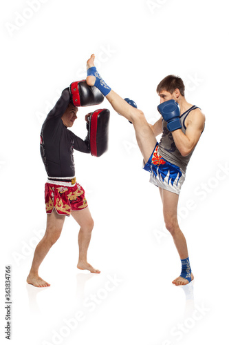 Two caucasian men exercising thai boxing in  studio on white background © Naz
