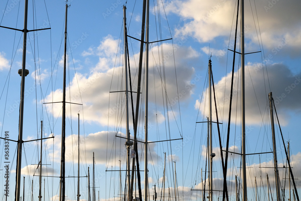 Yacht masts on a background of cloudy sky