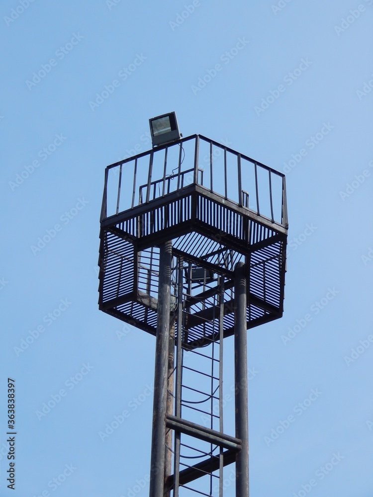 Metal tower lighting. Platform with spotlights on top of the lighting metal tower. Metal tower lighting. Platform with spotlights on top of the lighting metal tower.