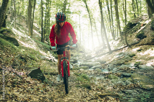 Mountain Bike cyclist woman riding bike in forest. Outdoor cyclist woman enjoying at nature.