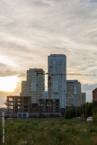 crane with a skyscraper on a sunset sky vertical