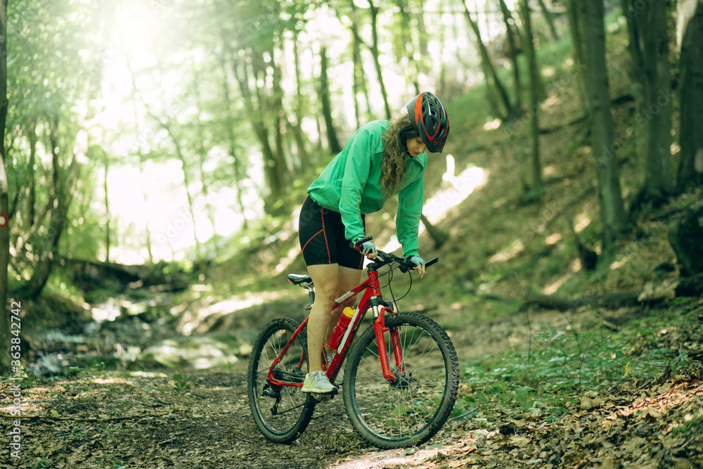 Mountain Bike cyclist woman riding bike in forest. Outdoor cyclist woman enjoying at nature.