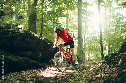 Mountain Bike cyclist woman riding bike in forest. Outdoor cyclist woman enjoying at nature.