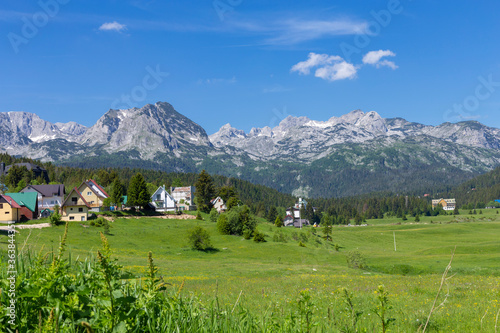 Houses on meadows and mountains of the highlands natural landscape near the town of Zabljak in the unspoilt countryside  Montenegro.