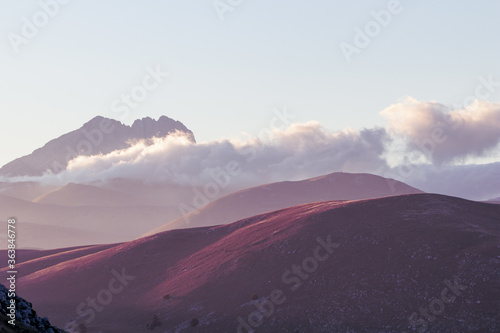 Filtered image. Mountain landscape at sunset with foggy clouds and golden light. Peaceful background and relax landscape. Banner, wallpaper images, backdrop and background with mountain peaceful light