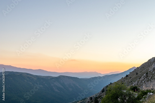 Mountain landscape at sunset with foggy clouds and golden light. Peaceful background and relax landscape. Banner and wallpaper images, backdrop and background with mountain peaceful light © PAOLO