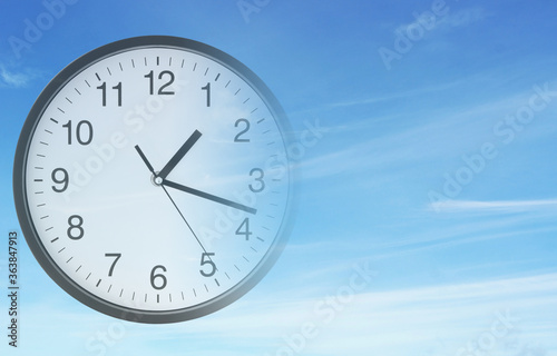Time passing concept, clock on blue sky background