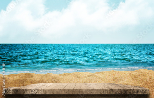 Wooden table top on blue sea and white sand beach background. 