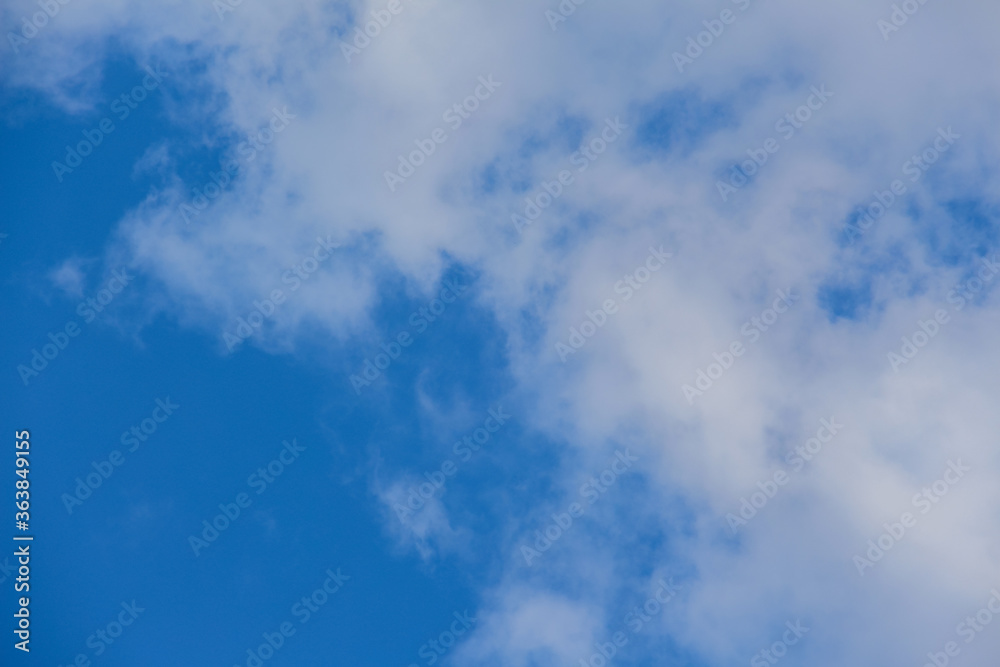 Beautiful blue sky with fluffy clouds. The concept of dreaminess and lightness. Meteorology and atmospheric phenomena. Different types of clouds. Layered clouds.