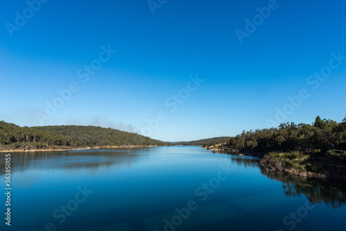 Mundaring Weir dam and its tranquil water in the afternoon on a late Winter day.