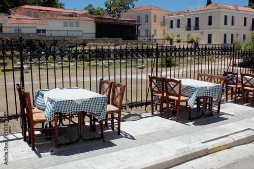 Fototapeta Naklejka Na Ścianę i Meble -  Greece, Athens, June 28 2020 - Empty chairs and tables of a traditional restaurant in the touristic district of Plaka. 