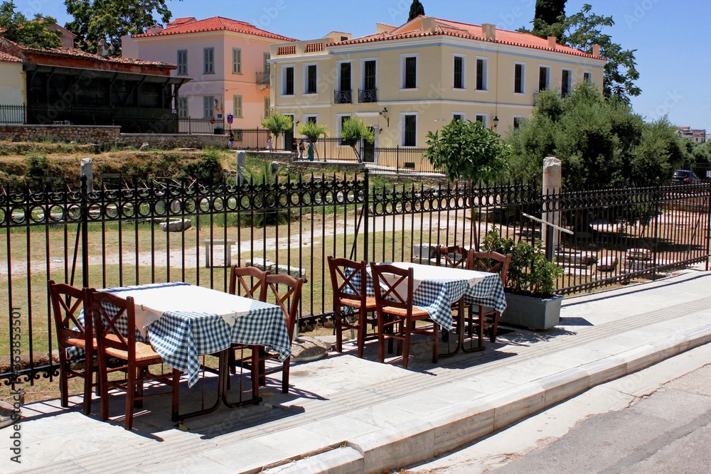 Fototapeta premium Greece, Athens, June 28 2020 - Empty chairs and tables of a traditional restaurant in the touristic district of Plaka.