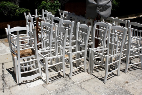 Greece, Athens, June 28 2020 - Chairs stacked outside of a traditional restaurant in the touristic district of Plaka.  photo